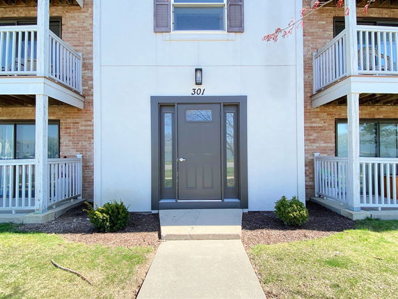 Front view of a building entrance with balconies on either side.