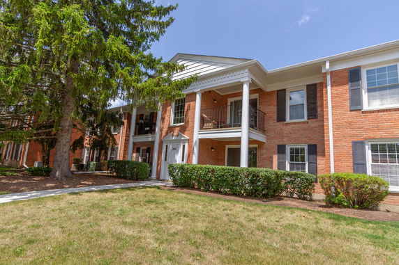 Front view of a two-story brick apartment building with balconies.