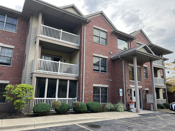 Front view of a three-story apartment building with balconies.