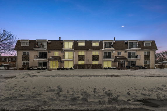 Front view of a multi-story residential building with balconies.
