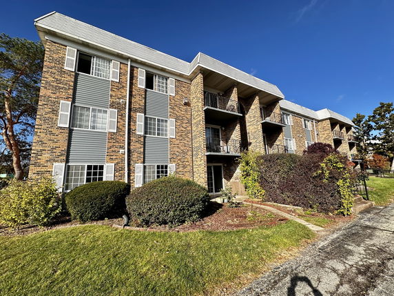Front view of a multi-story apartment building with balconies.