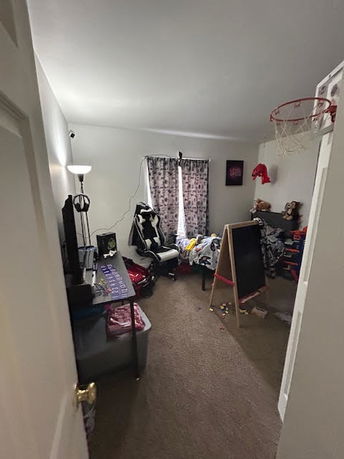 Room with a gaming chair, television, and various toys, used as an indoor play area.