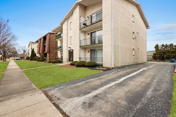 Front view of a multi-story apartment building with balconies.