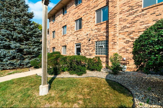 Front view of a brick multi-story apartment building.