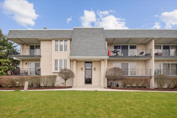 Front view of a two-story apartment building with balconies.