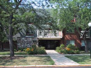 Front view of a multi-story residential building with a balcony.