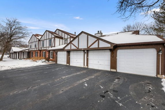 Front view of a house with multiple garages in a snowy setting.