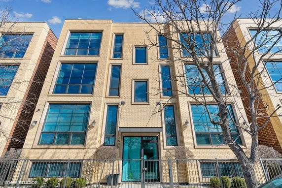 Front view of a multi-story modern building with large windows.