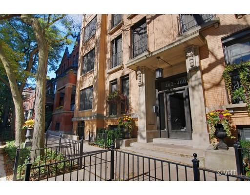 Front view of a multi-story brick building with decorative elements and a gated entrance.