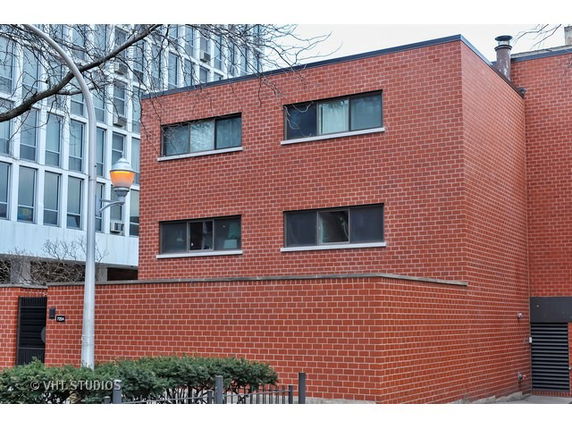 Front view of a two-story brick building with rectangular windows.