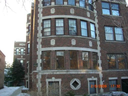 Front view of a multi-story brick building with numerous windows.