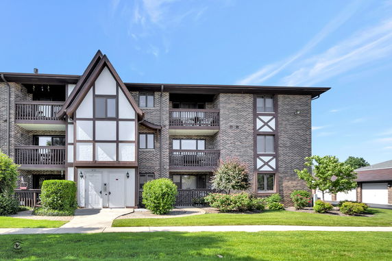 Front view of a multi-story residential building with a Tudor-style design.