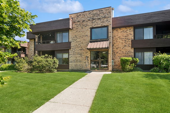 Front view of a two-story residential building with brick facade and brown accents.