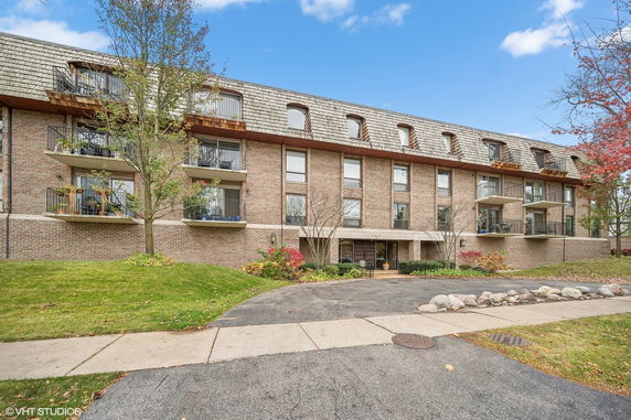 Front view of a multi-story apartment building with balconies.