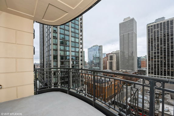 Panoramic view from a balcony in a high-rise building showing surrounding skyscrapers.