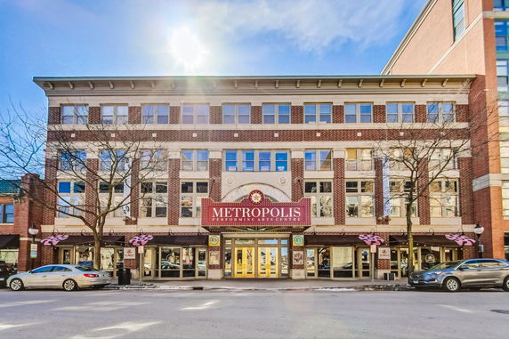 Front view of a multi-story building with a central entrance and a sign for the Metropolis Performing Arts Centre.
