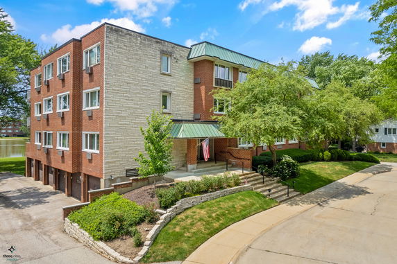 Front view of a multi-story residential building with brick and stone exterior.