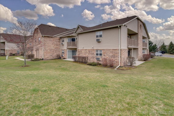 Front view of a two-story residential building with brick and siding exterior.