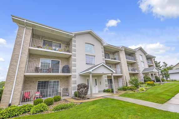 Front view of a multi-story apartment building with balconies.