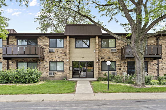 Front view of a two-story brick residential building with balconies.