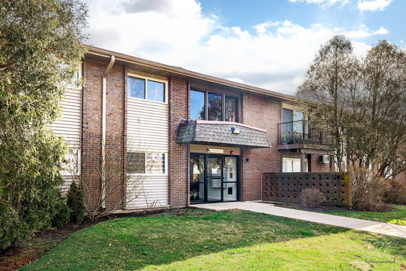 Front view of a two-story brick apartment building with a central entrance.