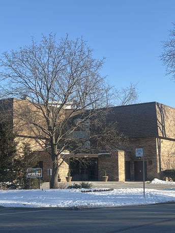 Front view of a multi-story brick building with a main entrance.