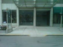 Front view of a building entrance with large glass doors and overhang.