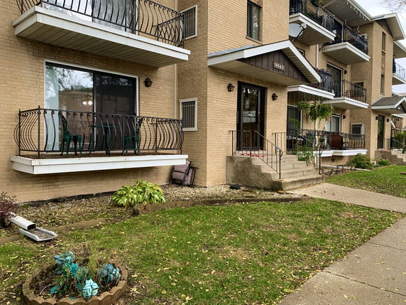 Front view of a multi-story apartment building with balconies.