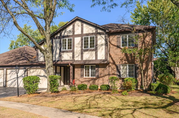 Front view of a two-story house with a brick facade and attached garage.