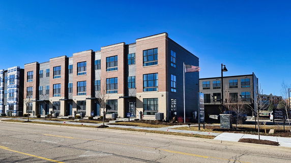 Front view of a modern multi-story row of townhouses.