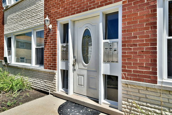 Front view of a house with a white door and brick exterior.