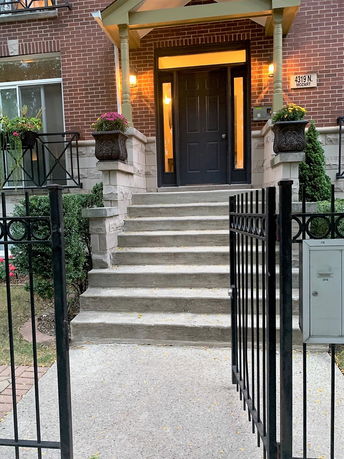 Front view of a house with a stairway leading to the entrance.