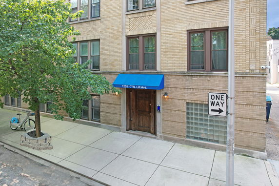 Front view of a multi-story building with a blue awning above the entrance.