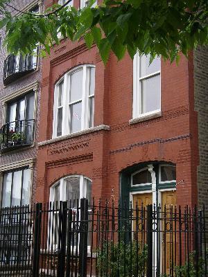 Front view of a multi-story brick building with arched windows.