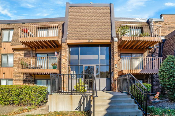 Front view of a multi-story building with balconies and a glass entrance.