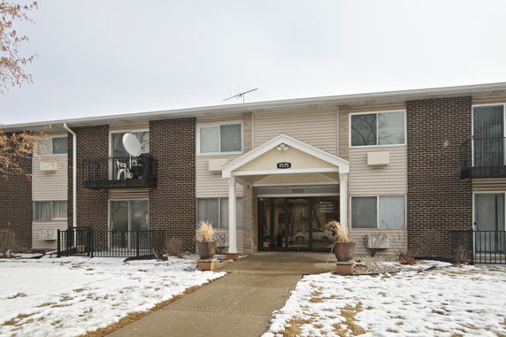 Front view of a two-story building with brick and siding exterior.