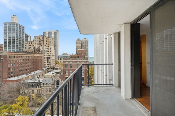 View from a balcony overlooking tall buildings in a cityscape.