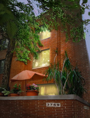Front view of a brick residential building with potted plants and an umbrella.
