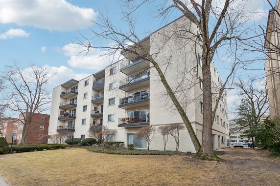 Front view of a multi-story apartment building with balconies.