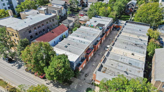 Aerial view of a row of flat-roofed buildings with a courtyard in between.