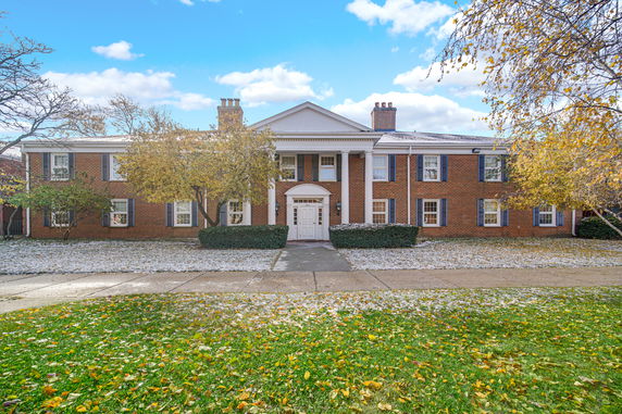 Front view of a large two-story brick building with white columns.