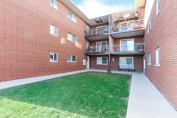 Front view of a brick apartment building with multiple balconies.