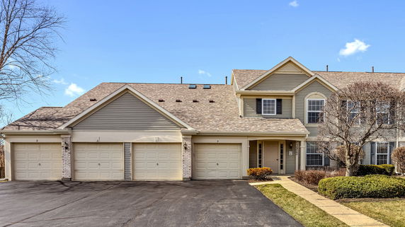 Front view of a multi-garage, two-story house with a gable roof.