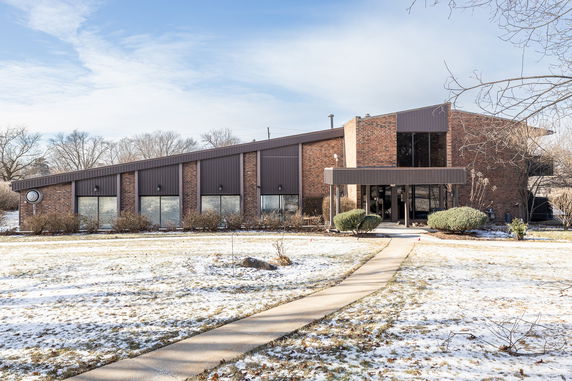 Front view of a contemporary building with large windows and brick facade.