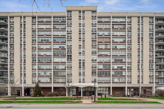 Front view of a multi-story apartment building with balconies.
