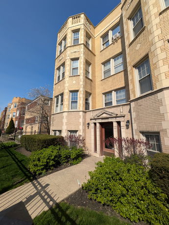 Front view of a multi-story brick apartment building with detailed masonry.