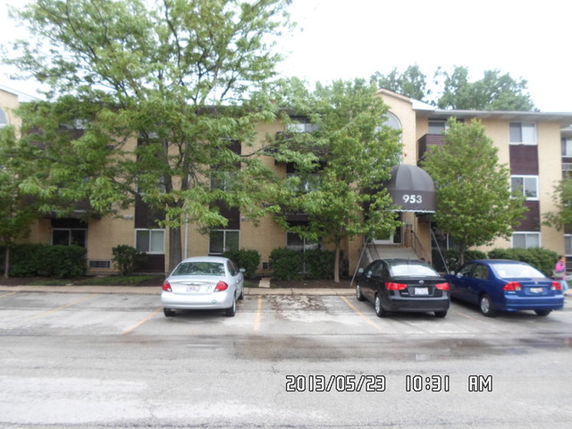 Front view of a multi-story residential building with a covered entrance.