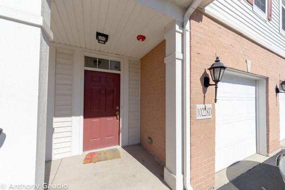 Front view of a house with a red front door and garage.