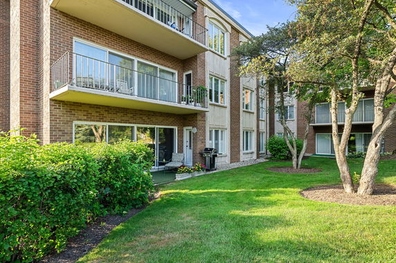 Front view of a brick apartment building with balconies and large windows.