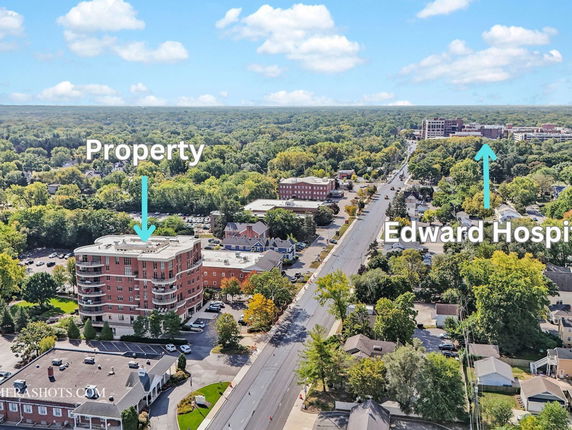 Aerial view of a neighborhood showing a multi-story building and surrounding areas.